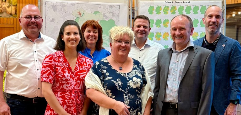 Mehrere Personen stehend vor einer Leinwand