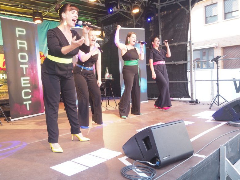 4 Frauen in schwarz gekleidet auf einer Bühne