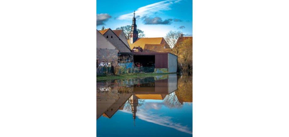 Ansicht Fachwerkhäuser und davor Wasser in dem sich die Fassaden spiegeln