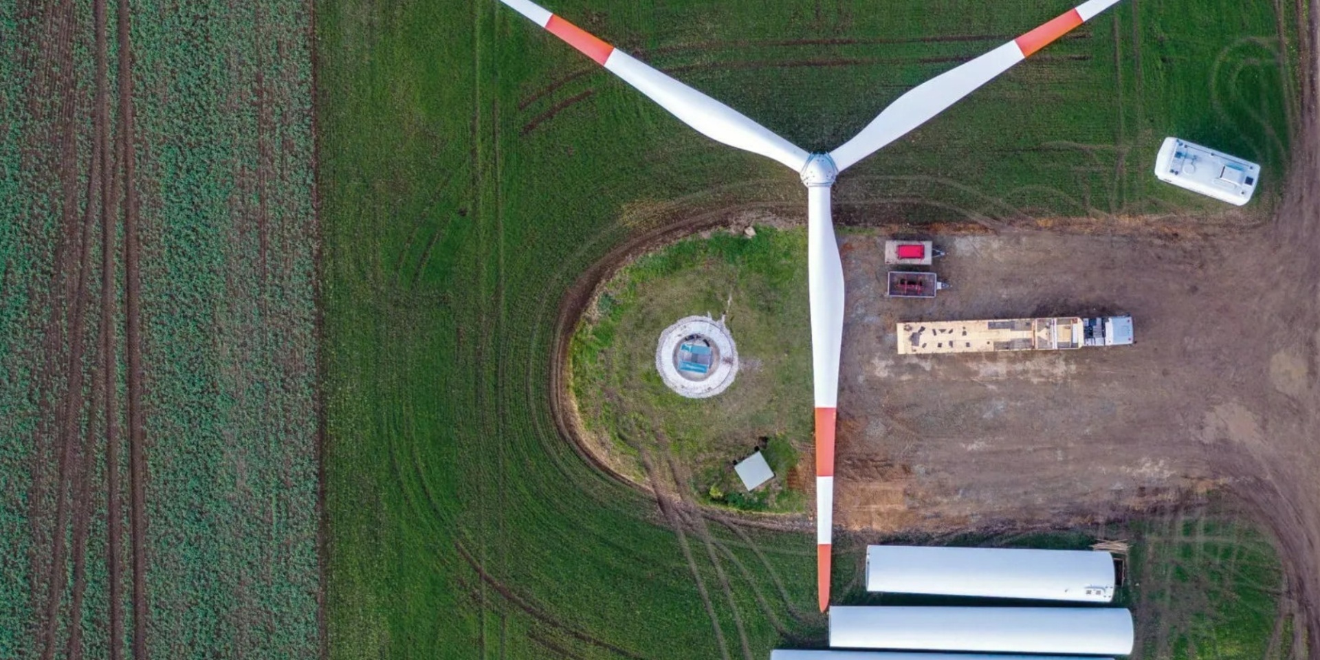 Ansicht von oben auf ein Windrad auf einem Feld, welches auseinander genommen wurde