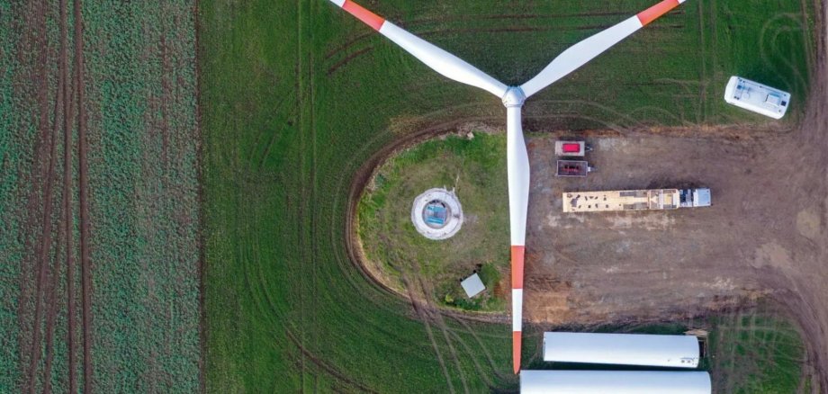 Ansicht von oben auf ein Windrad auf einem Feld, welches auseinander genommen wurde