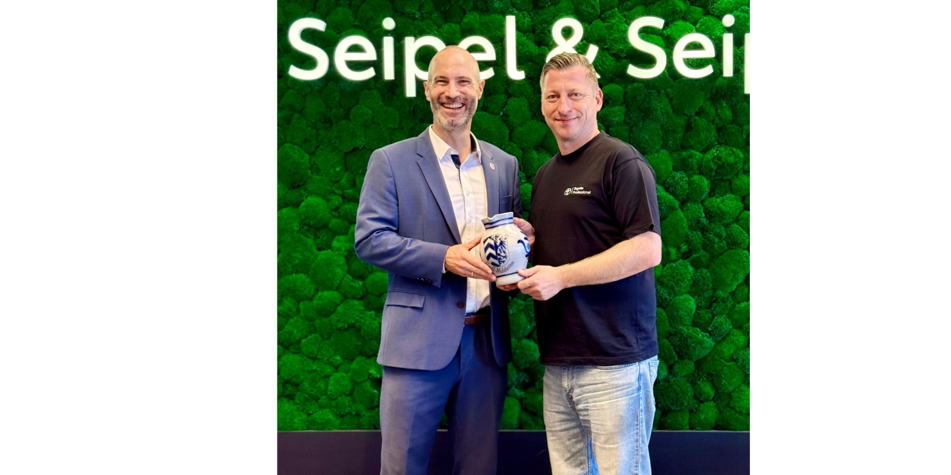 Zwei Männer stehend vor einem grünen Hintergrund.