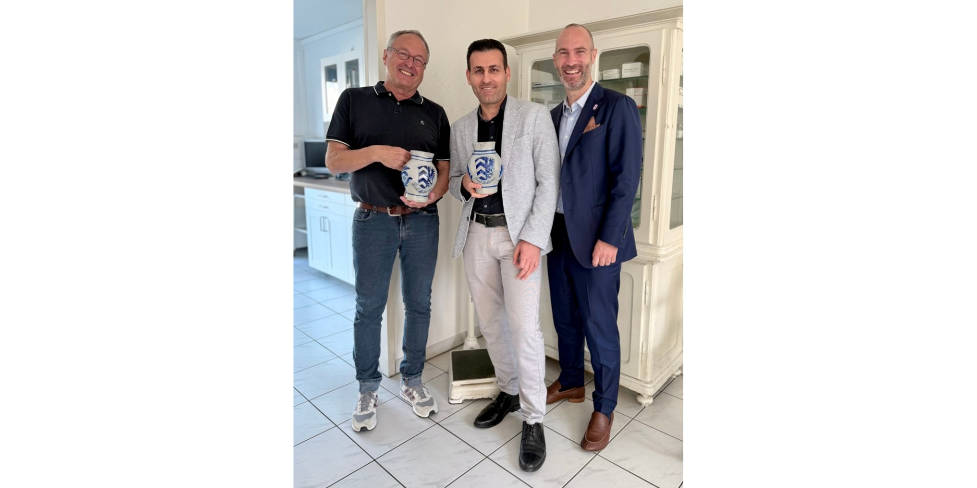 Drei Männer stehend, davon zwei einen Krug haltend (Bembel)