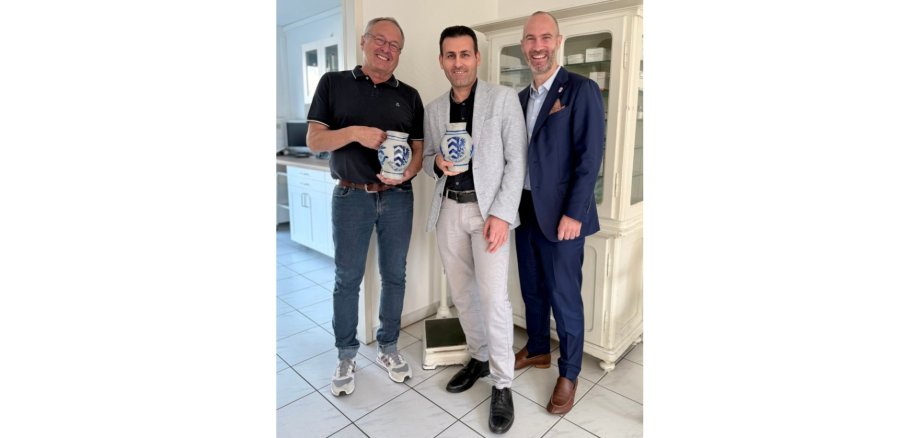 Drei Männer stehend, davon zwei einen Krug haltend (Bembel)