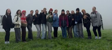 Mädchengruppe stehend auf einer Wiese im Nebel.