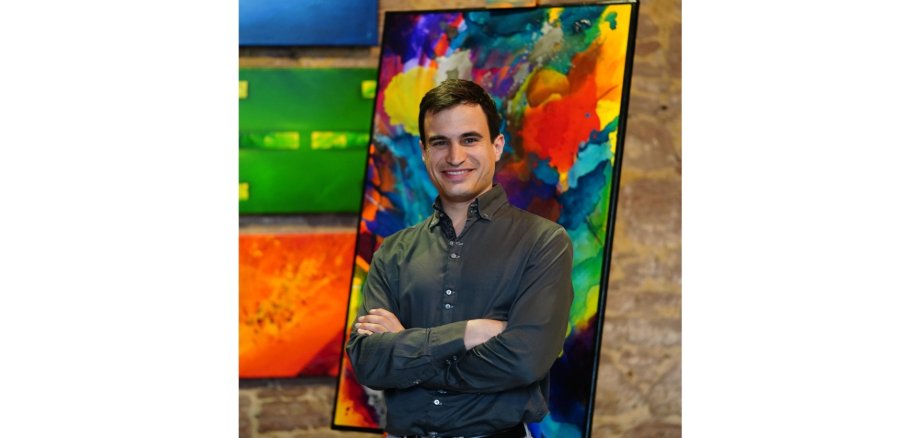 Ein Mann stehend vor einem Gemälde.