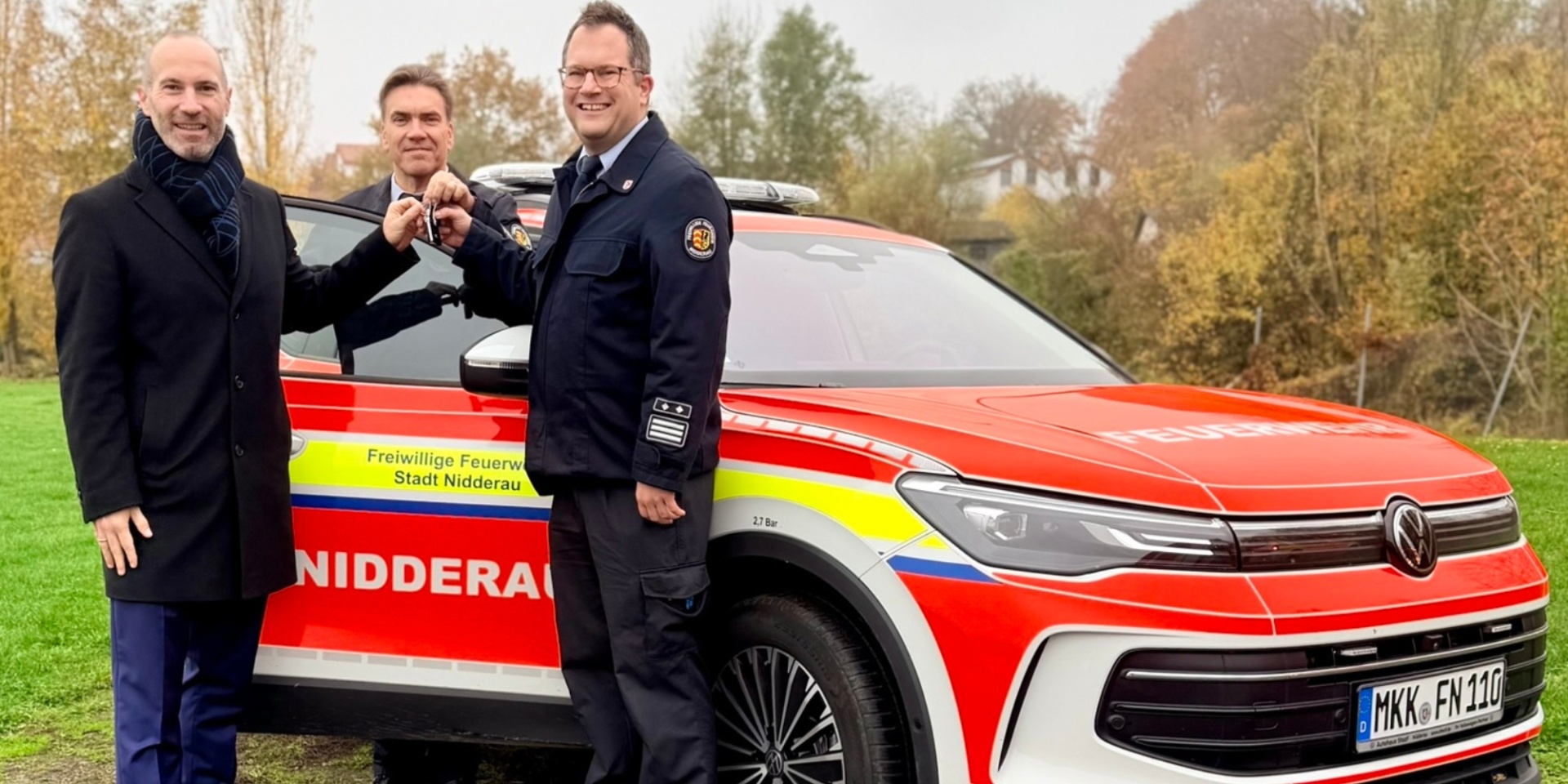 3 Männer stehend vor einem neuen PKW für die Feuerwehr