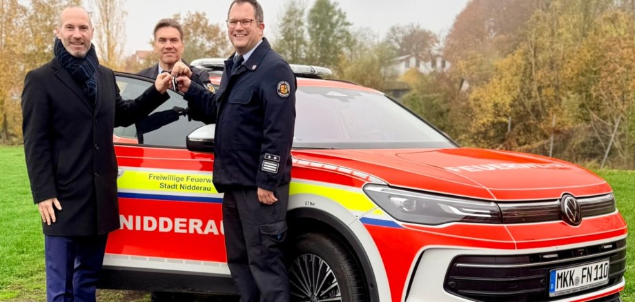 3 Männer stehend vor einem neuen PKW für die Feuerwehr