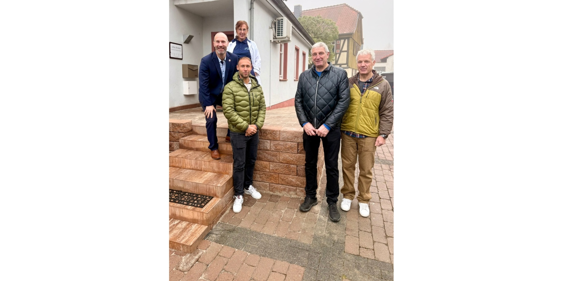 Vier Männer stehend vor einer Steintreppe