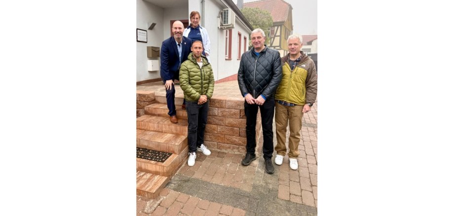 Vier Männer stehend vor einer Steintreppe