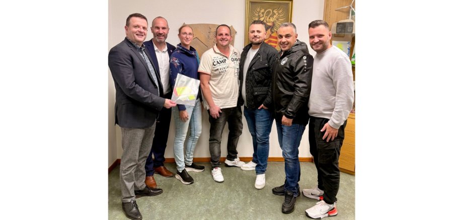 Eine Frau und sechs Männer stehend