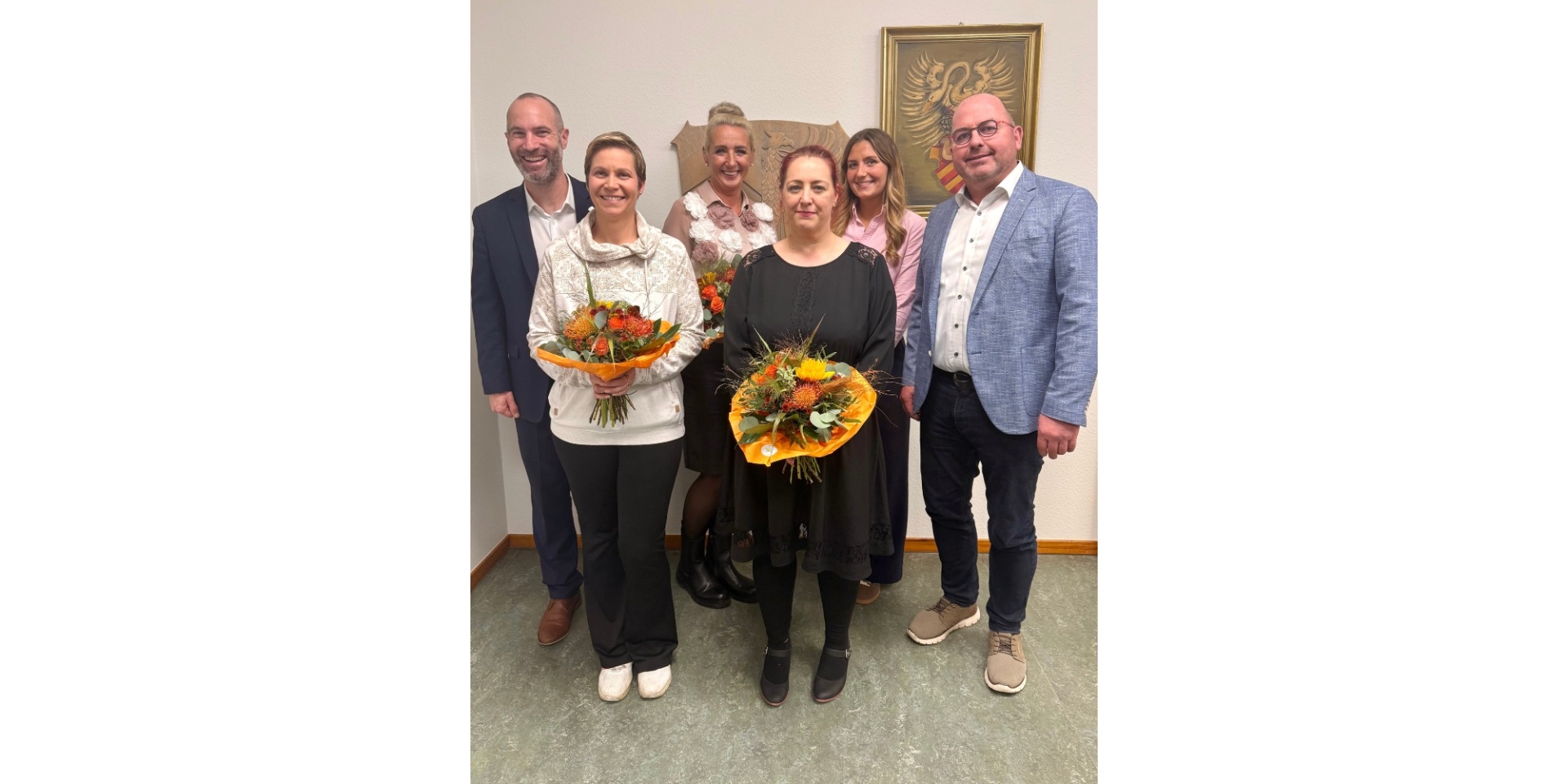 Vier Frauen und zwei Männer zusammenstehend