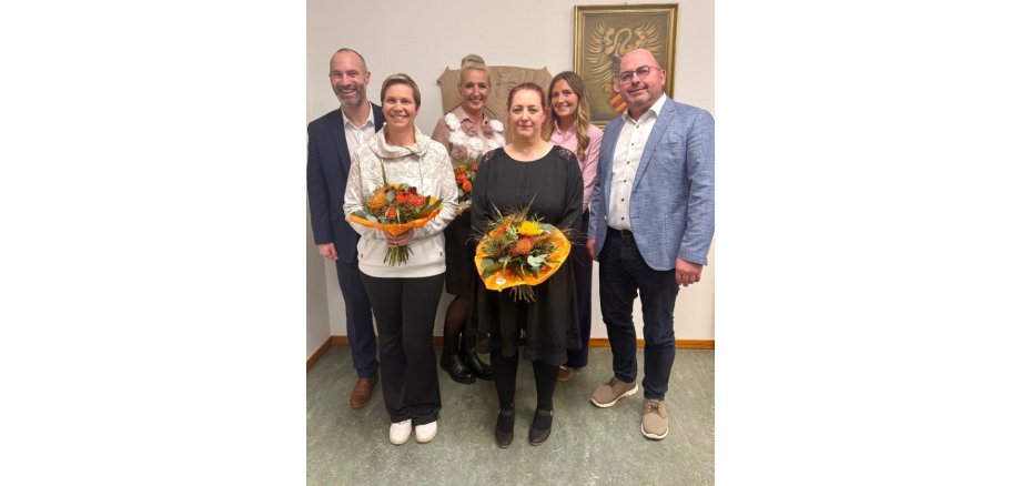 Vier Frauen und zwei Männer zusammenstehend