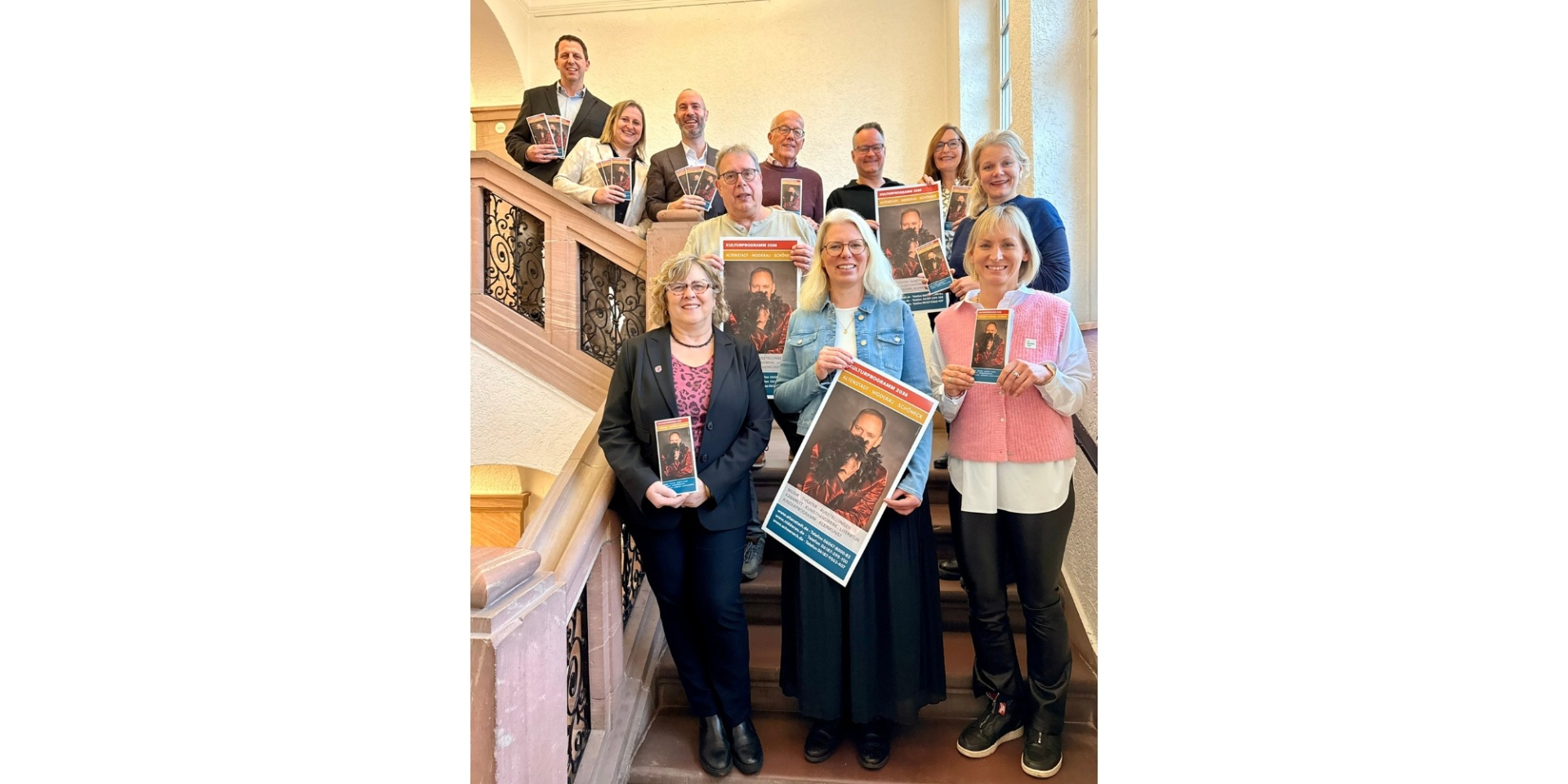 Mehrere Personen auf einer Treppe stehend und Flyer haltend