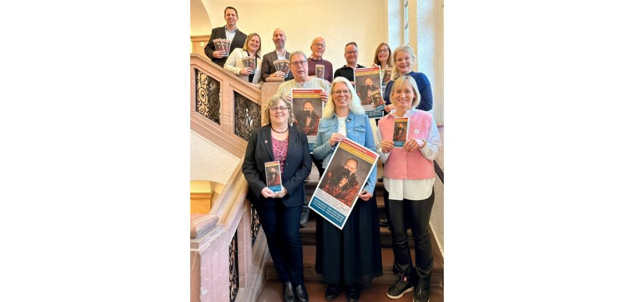 Mehrere Personen auf einer Treppe stehend und Flyer haltend