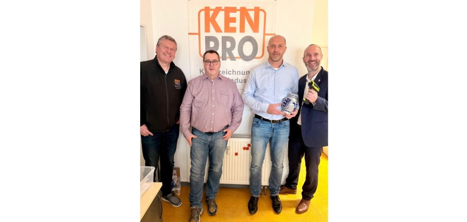 Vier Männer nebeneinander stehend. Ein Mann hält einen Krug (hessischer Bembel) in der Hand