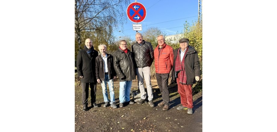 Mehrere Personen stehend vor einem Halteverbotsschild