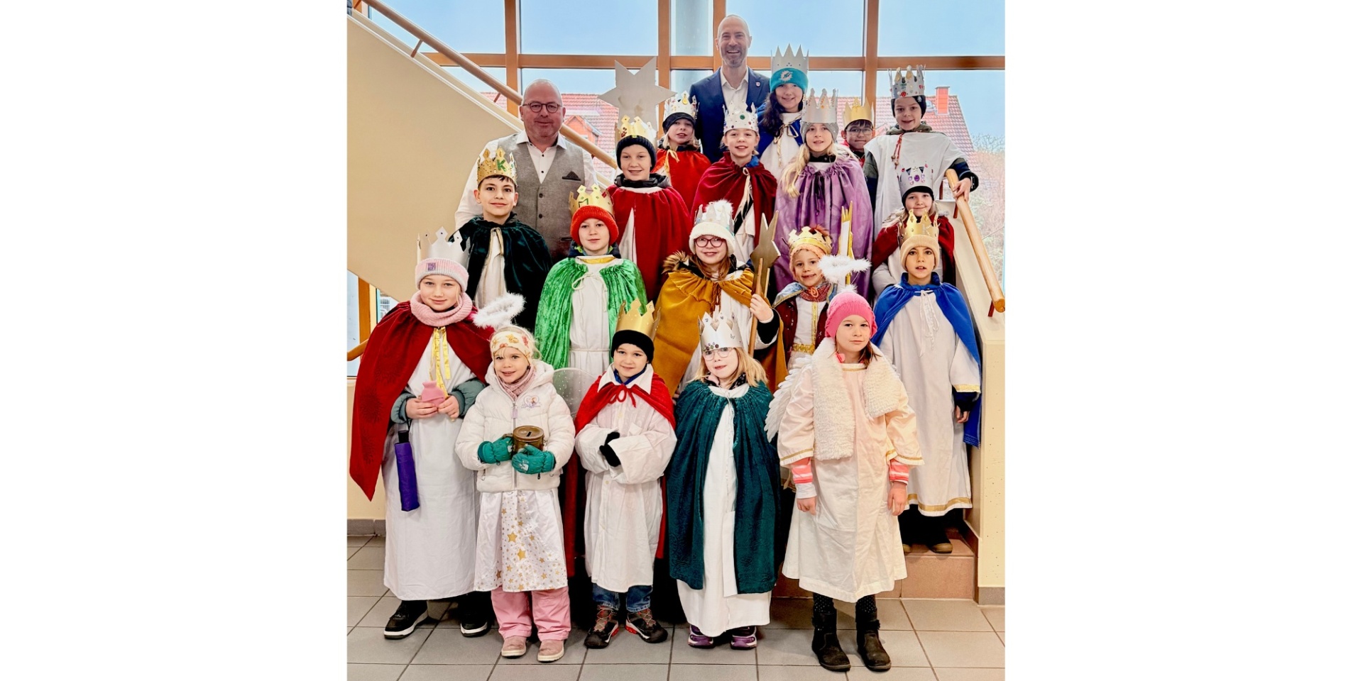 Zwei Männer und eine Gruppe Kinder auf einer Treppe stehend.