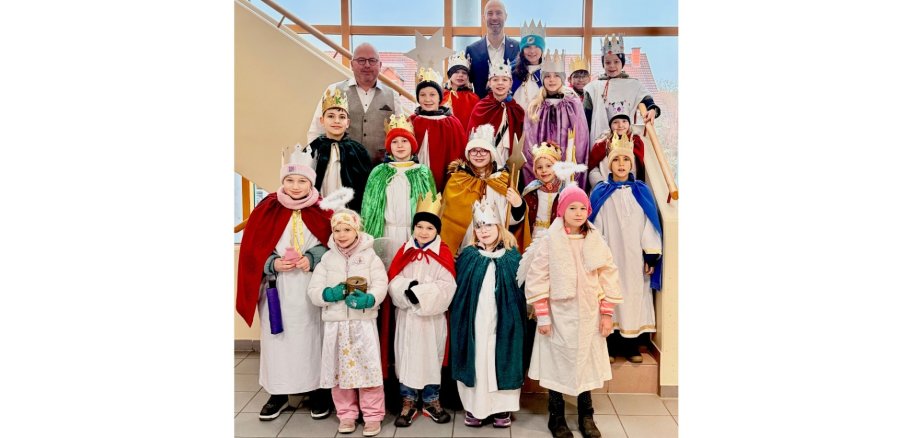 Zwei Männer und eine Gruppe Kinder auf einer Treppe stehend.