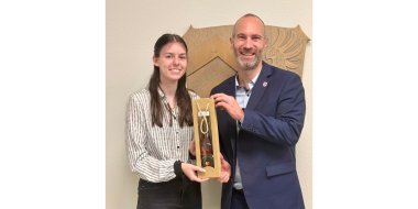 Eine Frau und ein Mann stehend vor einer Wand.