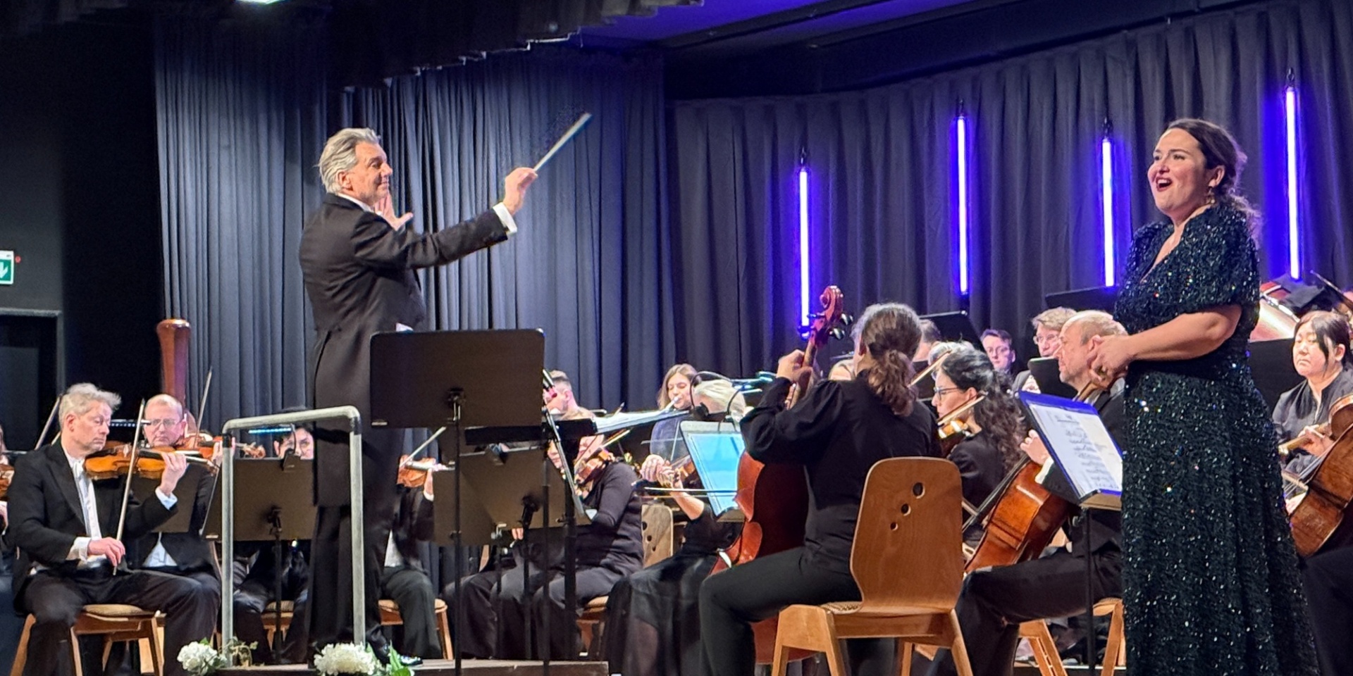 Musiker und Sängern mit Dirigent auf einer Bühne