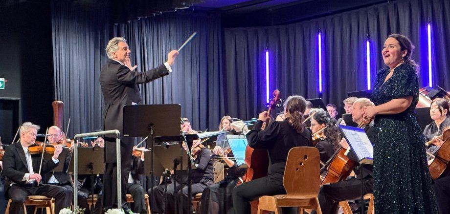 Musiker und Sängern mit Dirigent auf einer Bühne