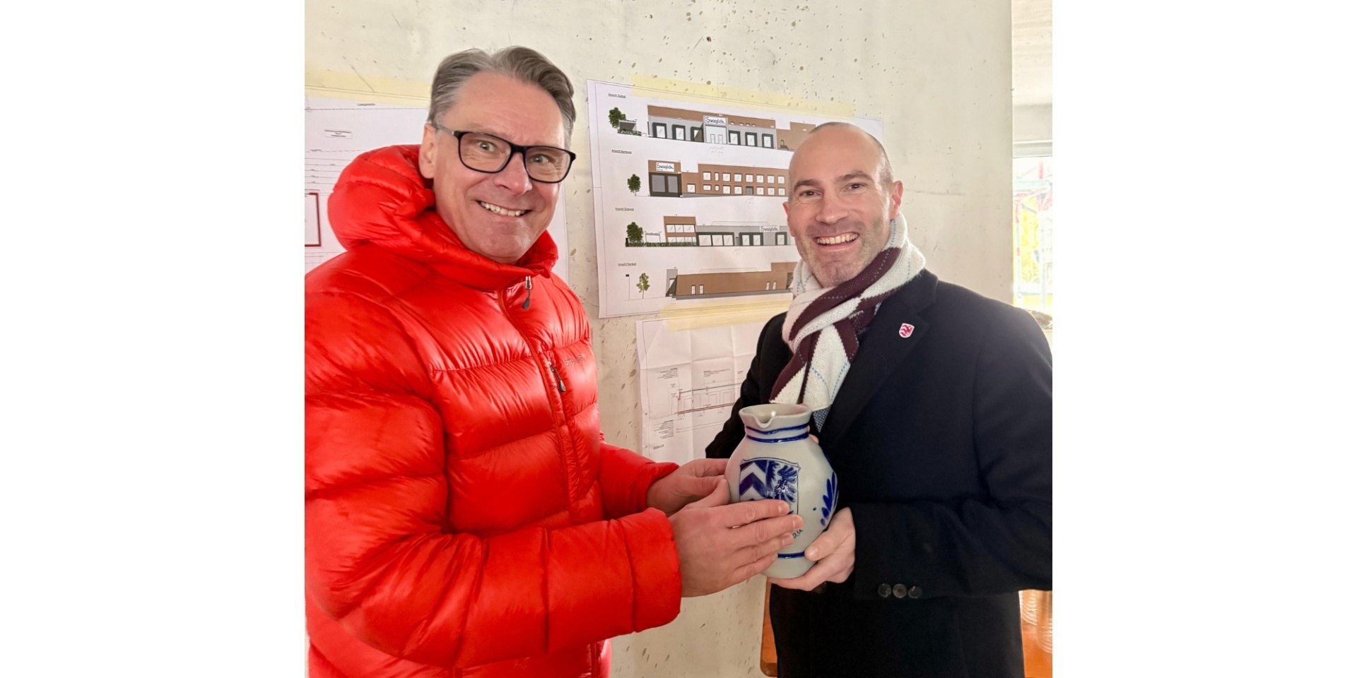 Zwei Männer stehend und lächelnd mit einem Apfelweinkrug in der Hand.