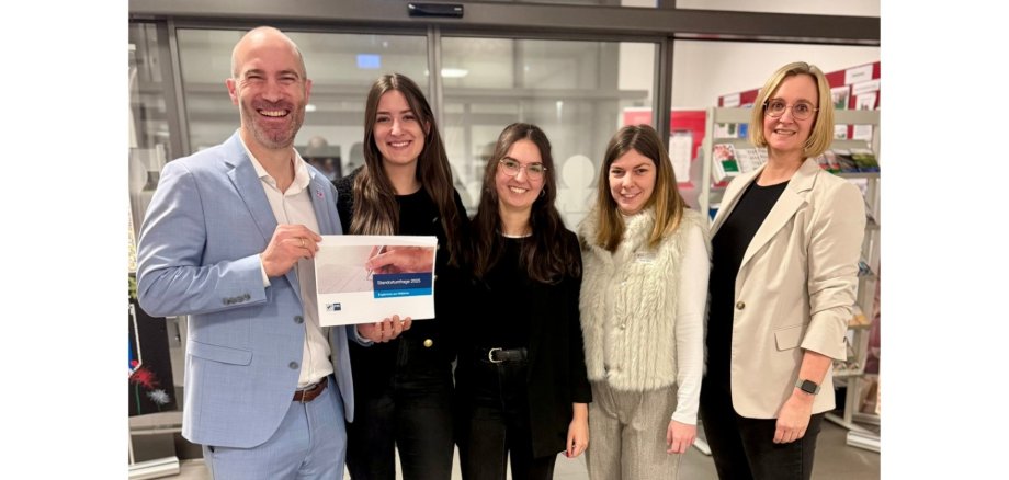 Ein Mann und vier Frauen stehend.