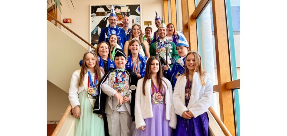 Verkleidete, gemischte Gruppe stehend auf einer Treppe in einem Gebäude.