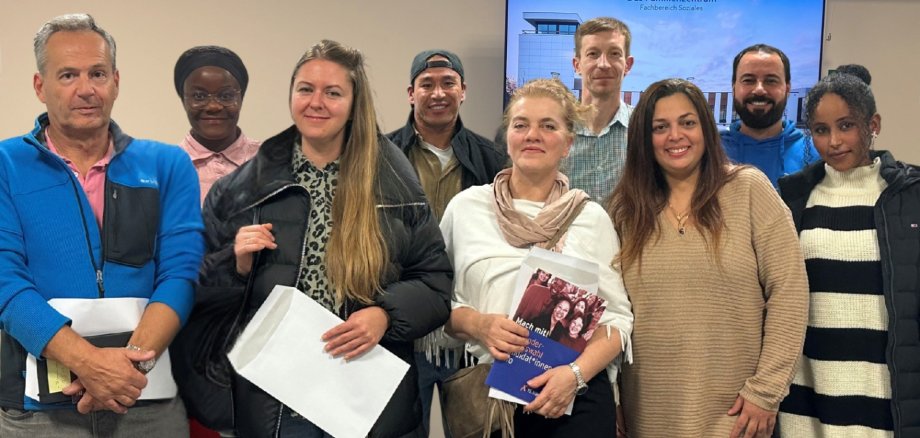 Mehrere Personen aus verschiedenen Nationen stehend nebeneinander