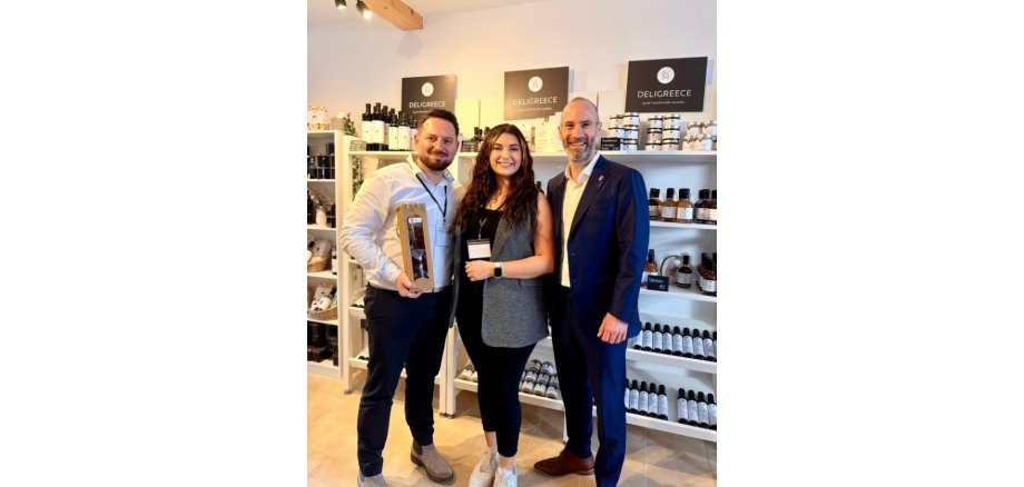 Zwei Männer und eine Frau stehend in einem Delikatessengeschäft