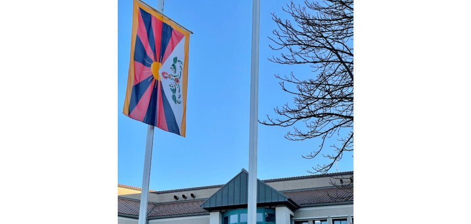 Bunte gehisste Fahne vor einem Gebäude