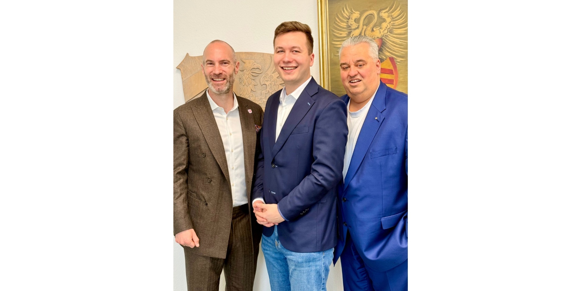 Drei Männer in Anzügen stehend nebeneinander