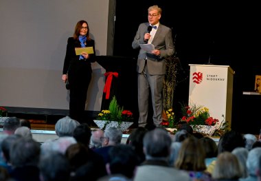 Ein  Mann und eine Frau stehend auf einer Bühne