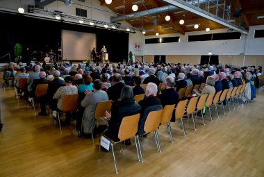 Mehrere Personen sitzend in einem Saal