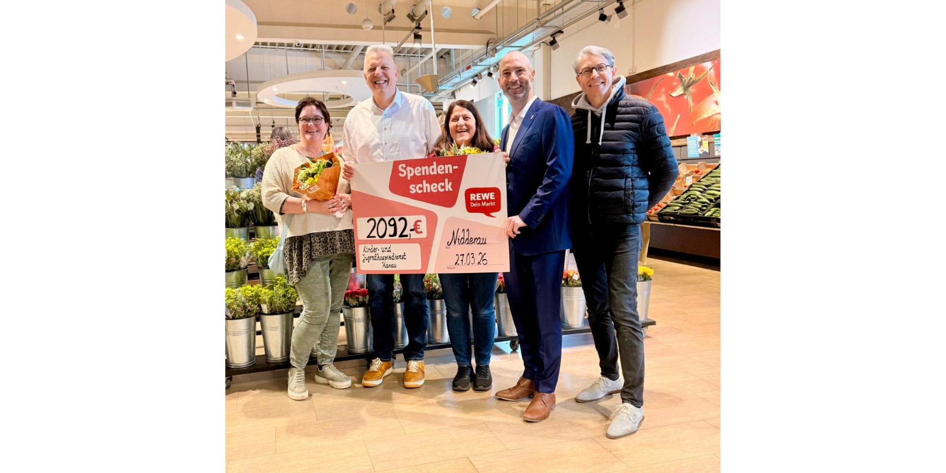 Zwei Frauen und drei Männer stehend in einem Einkaufsmarkt. 