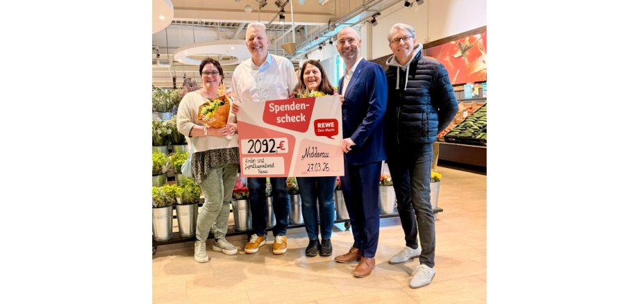 Zwei Frauen und drei Männer stehend in einem Einkaufsmarkt. 
