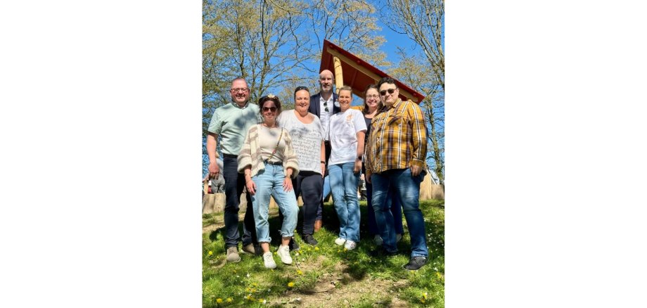 Mehrere Personen stehend auf einem Spielplatzgelände