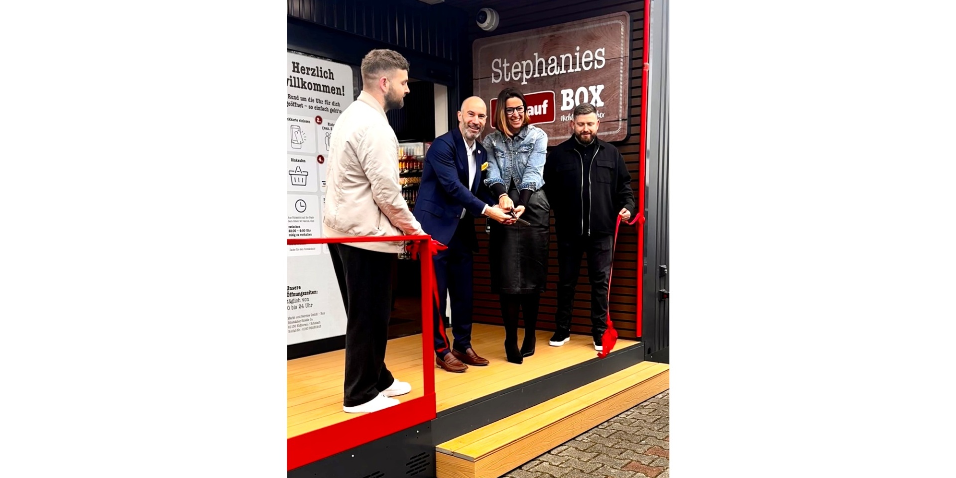 Mehrere Personen weihen einen Supermarkt-Container ein