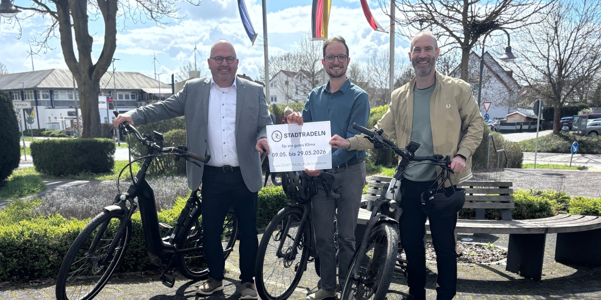 Drei Männer mit jeweils einem Fahrrad stehen nebeneinander