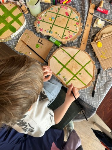 Kinder bemalen Baumscheiben
