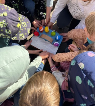 Kinder halten eine Schachtel mit bunten Ostereiern