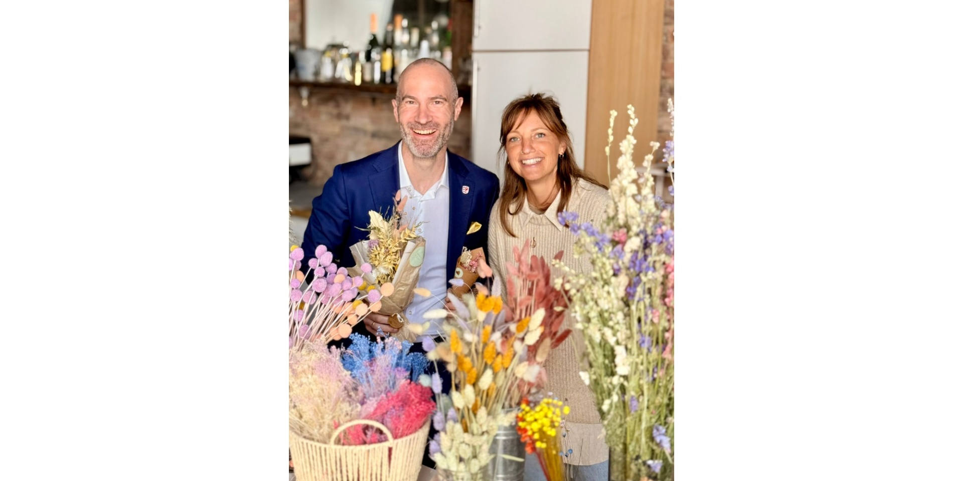 Ein Mann und eine Frau hinter Trockenblumen
