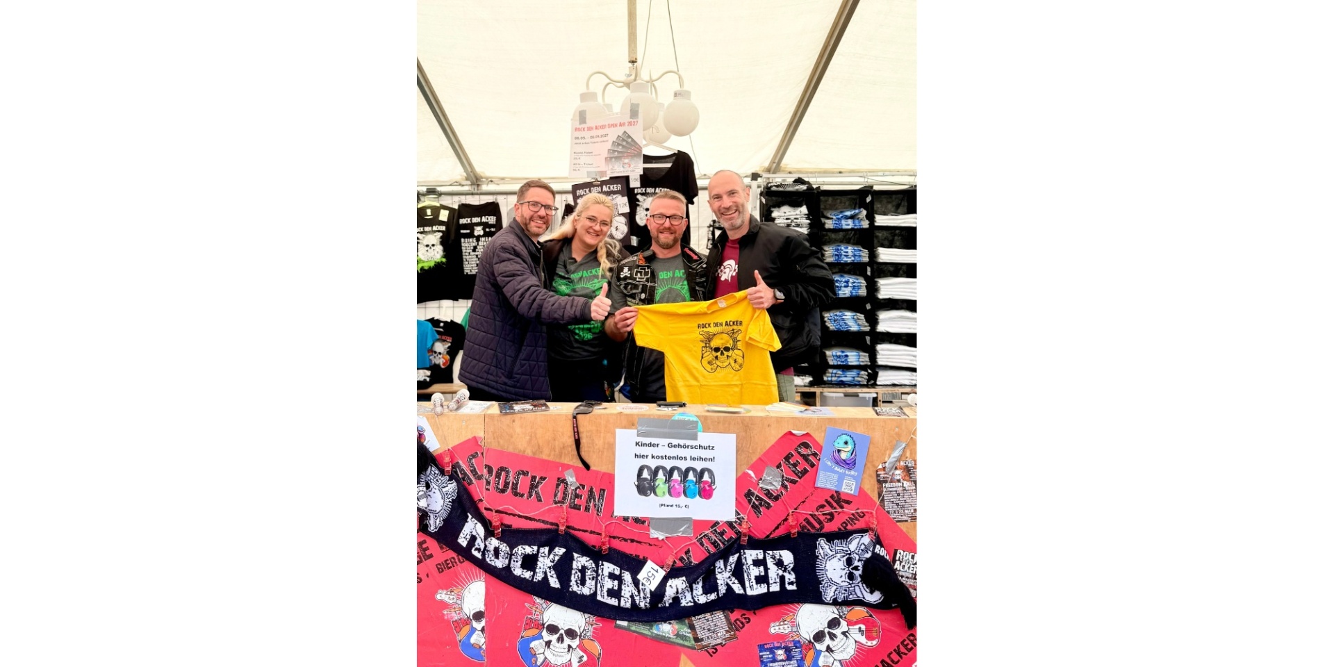 Drei Männer und eine Frau stehen hinter einem Tresen auf einem Festival