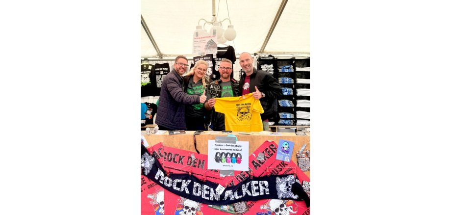 Drei Männer und eine Frau stehen hinter einem Tresen auf einem Festival