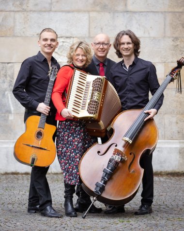 Drei Männer und eine Frau mit Musikinstrumenten