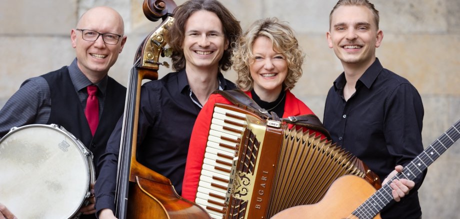 Drei Männer und eine Frau mit Musikinstrumenten