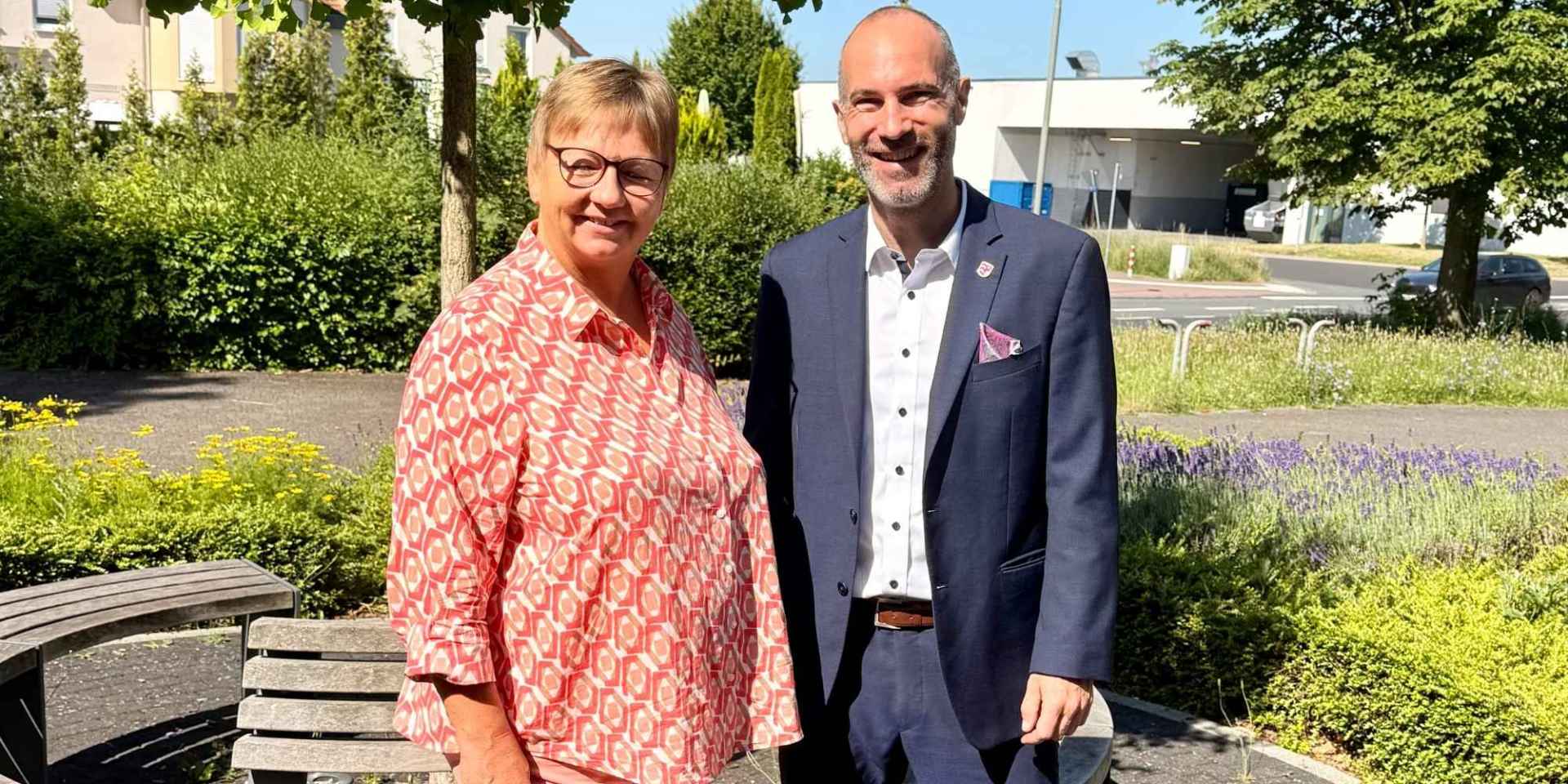 Eine Frau und ein Mann stehen nebeneinander vor einem Baum