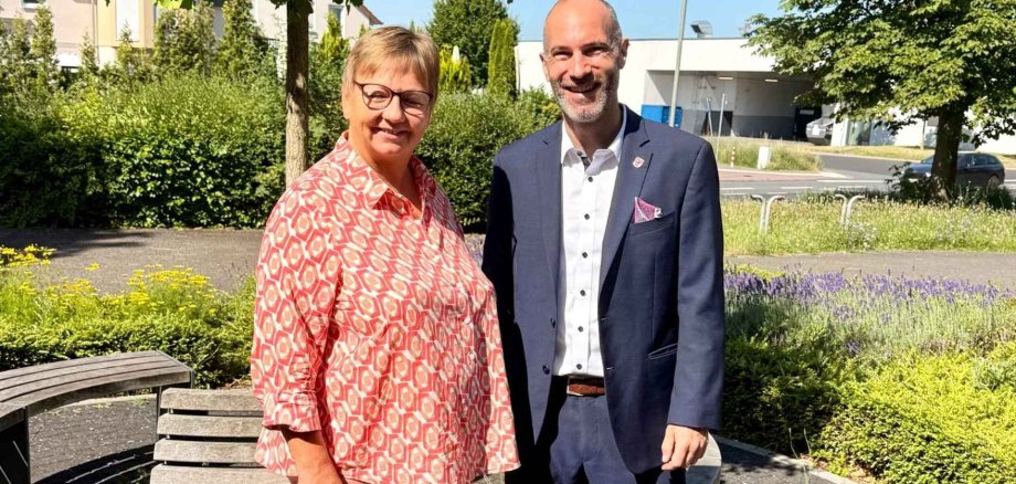 Eine Frau und ein Mann stehen nebeneinander vor einem Baum