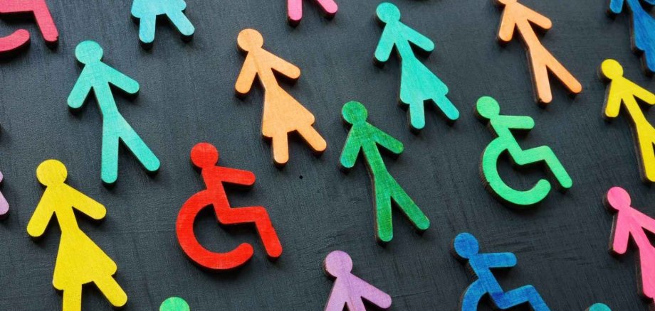 Bunte Strichmännchen in weiblicher und männlicher Form und mit Rollstuhl